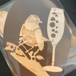 a beautiful bookmark made from birch bark, featuring a bird on a brunch glass of wine design