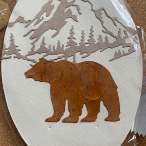  A majestic bear walks serenely in the foreground, set against a stunning mountain landscape.